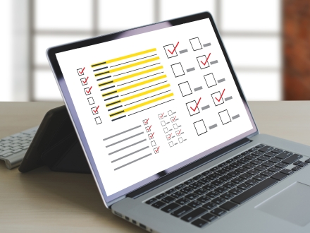 Laptop computer screen open to a survey page with boxes check marked